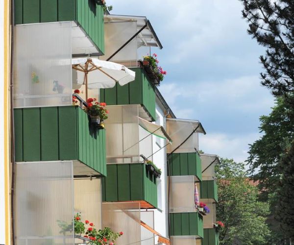 Mehrfamilienhaus mit grünen Balkonen